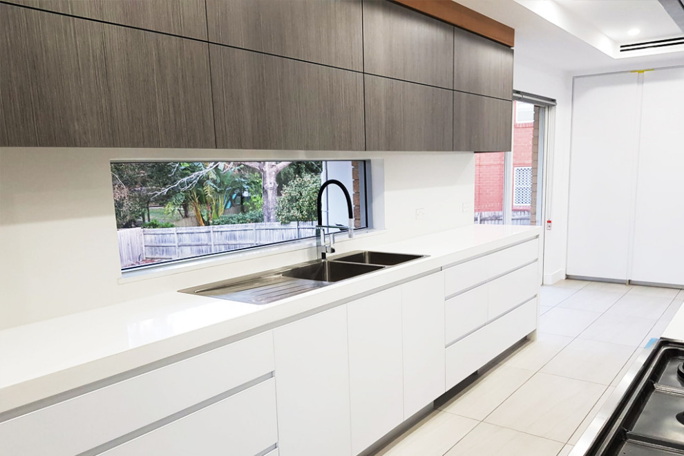 Eat-in kitchen - mid-sized contemporary galley eat-in kitchen idea in Sydney with a double-bowl sink, flat-panel cabinets, white cabinets, marble countertops, yellow backsplash, an island and white countertops