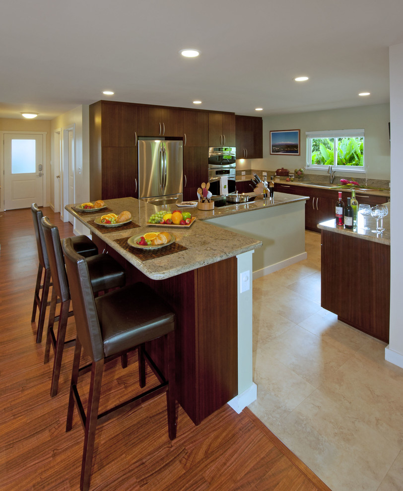 Large island style u-shaped ceramic tile and beige floor kitchen photo in Hawaii with an undermount sink, flat-panel cabinets, medium tone wood cabinets, granite countertops, stainless steel appliances and an island
