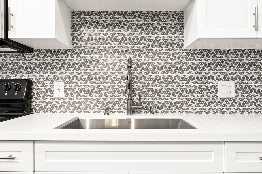 Foto di una piccola cucina con ante in stile shaker, ante bianche, top in quarzo composito, paraspruzzi multicolore, paraspruzzi con piastrelle a mosaico e top bianco