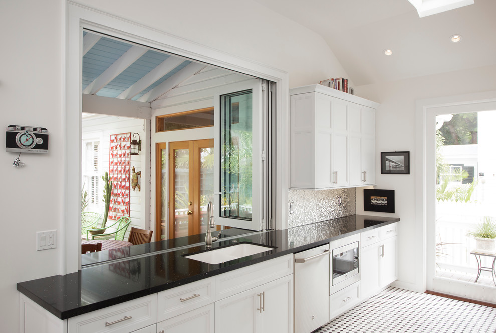 Modern inredning av ett mellanstort kök, med en dubbel diskho, skåp i shakerstil, vita skåp, granitbänkskiva, stänkskydd med metallisk yta, stänkskydd i metallkakel, rostfria vitvaror och klinkergolv i keramik