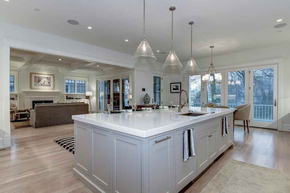 Inspiration for a huge transitional l-shaped light wood floor and beige floor open concept kitchen remodel in DC Metro with an island, an undermount sink, shaker cabinets, gray cabinets, solid surface countertops, white backsplash, marble backsplash and stainless steel appliances