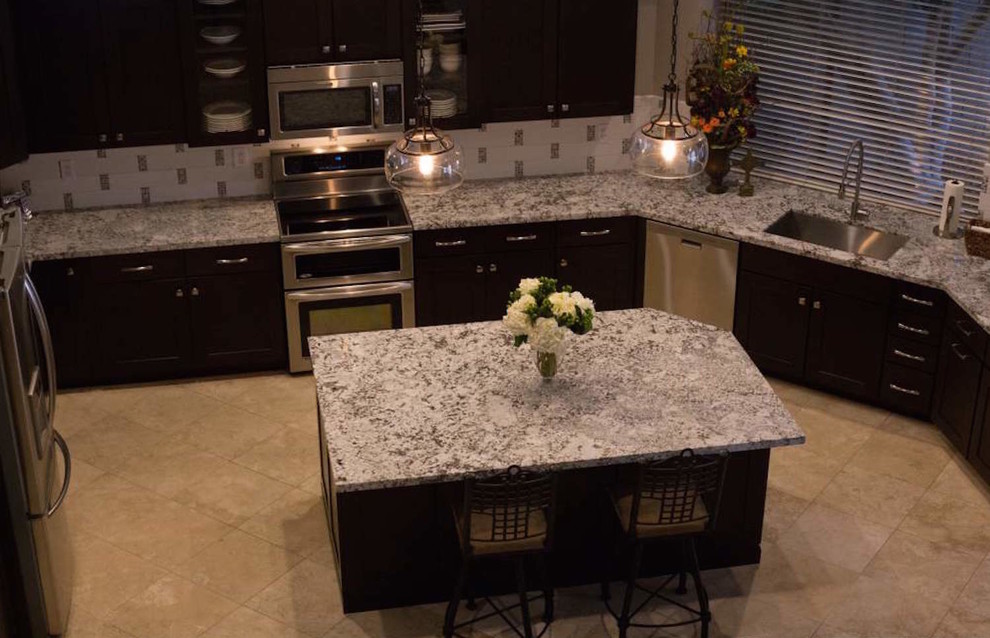 Example of a transitional u-shaped slate floor eat-in kitchen design in Phoenix with an undermount sink, shaker cabinets, dark wood cabinets, granite countertops, beige backsplash, subway tile backsplash, stainless steel appliances and an island
