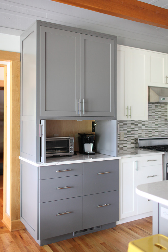 Exempel på ett mellanstort modernt vit vitt kök, med skåp i shakerstil, vita skåp, bänkskiva i kvartsit, flerfärgad stänkskydd, glaspanel som stänkskydd, rostfria vitvaror, mellanmörkt trägolv, en köksö, brunt golv och en undermonterad diskho