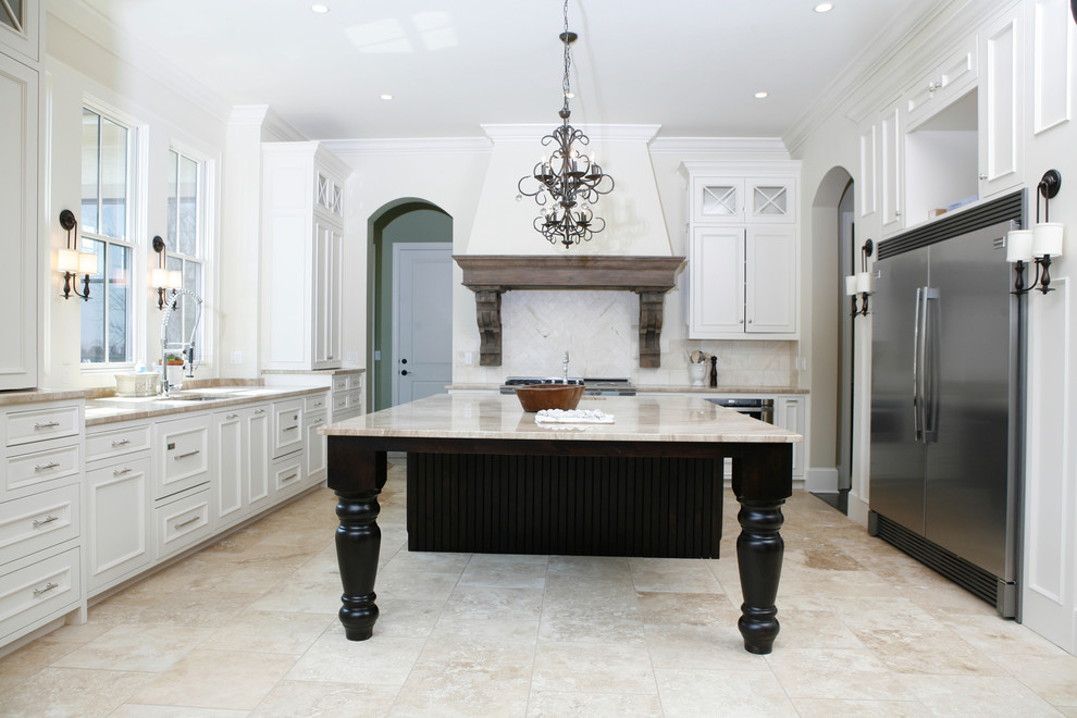 Inredning av ett mycket stort kök, med en nedsänkt diskho, luckor med upphöjd panel, vita skåp, marmorbänkskiva, beige stänkskydd, stänkskydd i stenkakel, rostfria vitvaror, travertin golv och en köksö
