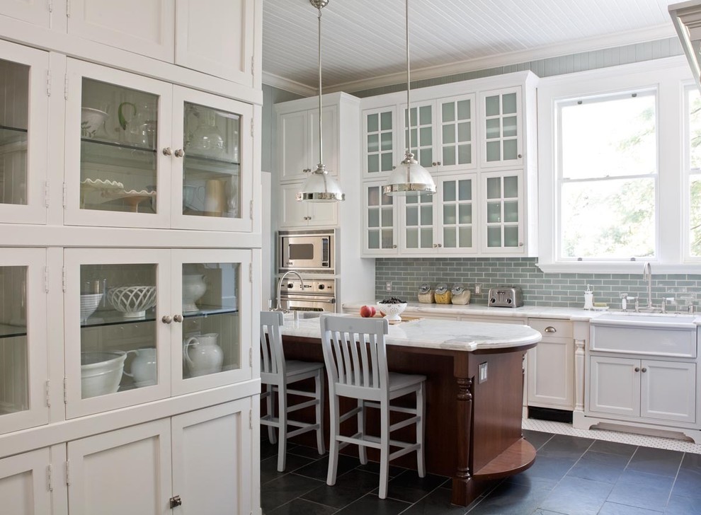 This is an example of a traditional kitchen in San Francisco with glass-front cabinets, stainless steel appliances and a belfast sink.