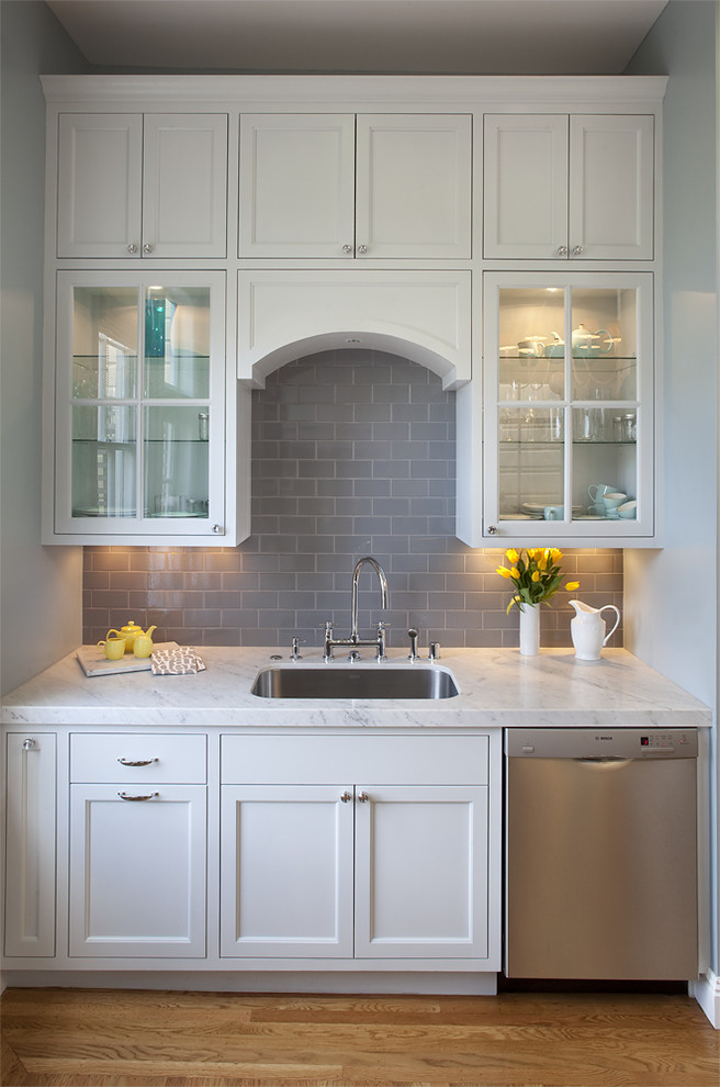 Elegant kitchen photo in San Francisco with glass-front cabinets, subway tile backsplash and stainless steel appliances