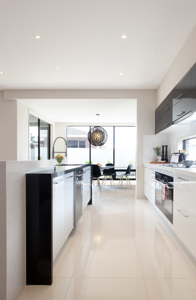 Moderne Wohnküche mit flächenbündigen Schrankfronten, weißen Schränken und weißem Boden in Melbourne