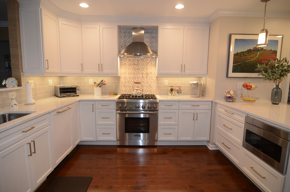 Idéer för att renovera ett stort vintage vit vitt kök, med luckor med infälld panel, vita skåp, bänkskiva i kvarts, beige stänkskydd, rostfria vitvaror, mörkt trägolv, en halv köksö och brunt golv