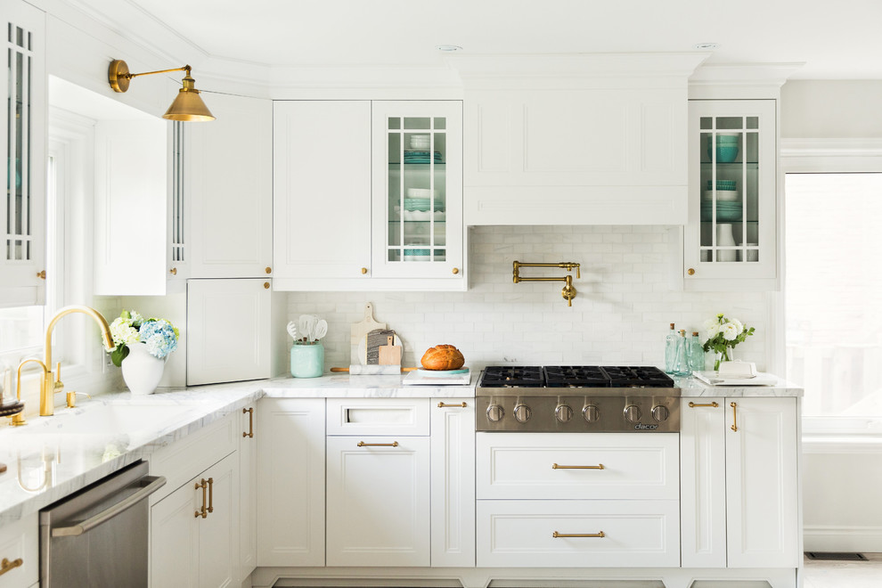 Example of a farmhouse kitchen design in Toronto with an undermount sink, beaded inset cabinets, white cabinets, white backsplash and stainless steel appliances