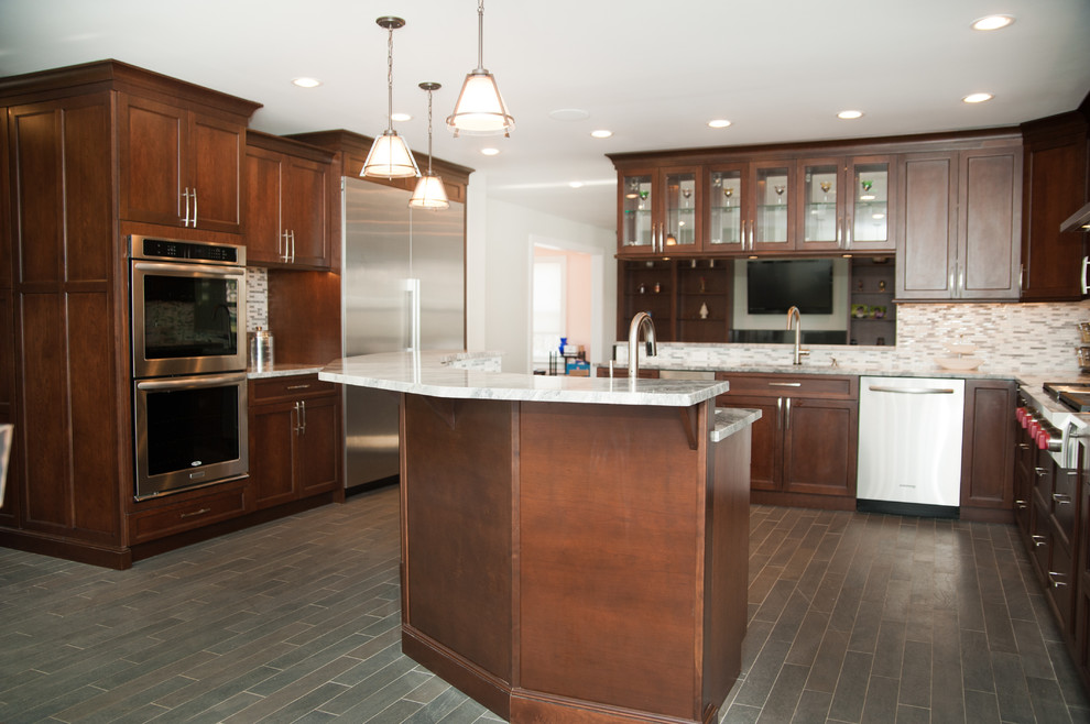 Modern inredning av ett stort kök, med en undermonterad diskho, granitbänkskiva, flerfärgad stänkskydd, stänkskydd i stenkakel, rostfria vitvaror och klinkergolv i porslin