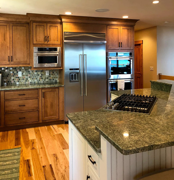 Kitchen - large transitional l-shaped medium tone wood floor and brown floor kitchen idea in Boston with a farmhouse sink, shaker cabinets, medium tone wood cabinets, granite countertops, multicolored backsplash, glass tile backsplash, stainless steel appliances and an island