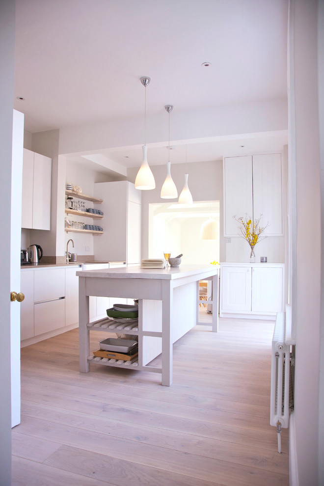 Foto di una cucina costiera di medie dimensioni con top in superficie solida, paraspruzzi bianco, top bianco, soffitto a volta, ante lisce, ante bianche, parquet chiaro e pavimento marrone