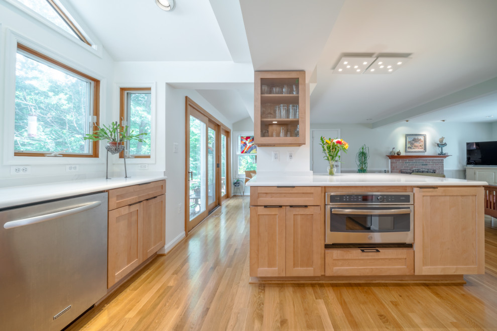Mittelgroße Moderne Wohnküche mit Doppelwaschbecken, hellen Holzschränken, Granit-Arbeitsplatte, Küchengeräten aus Edelstahl, hellem Holzboden und braunem Boden in Washington, D.C.