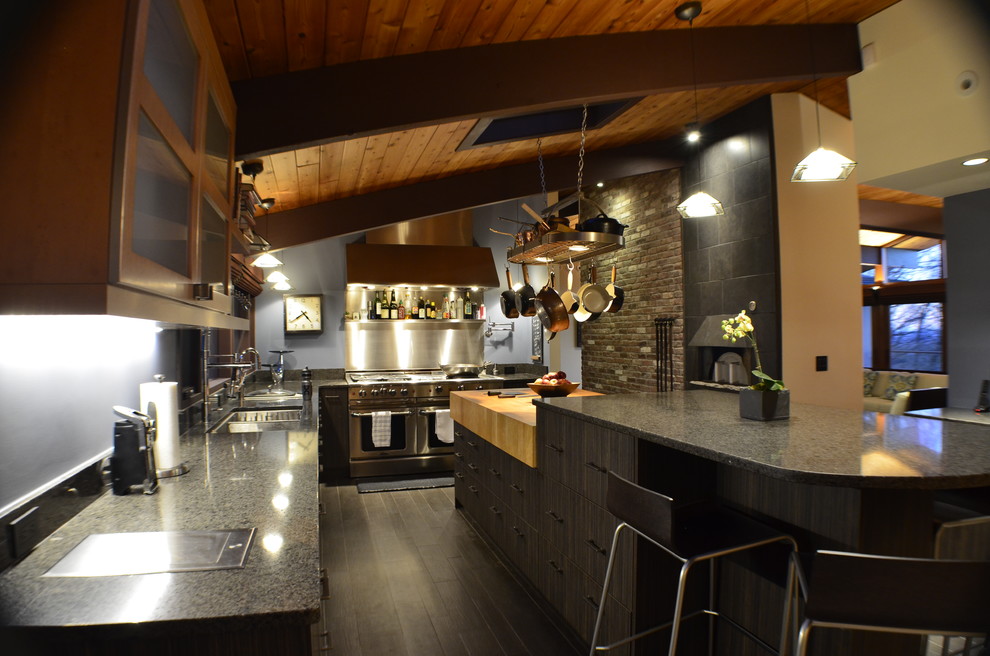 Photo of a large rustic kitchen in Boston with a submerged sink, flat-panel cabinets, dark wood cabinets, wood worktops, brick splashback, stainless steel appliances, porcelain flooring, multiple islands and black floors.
