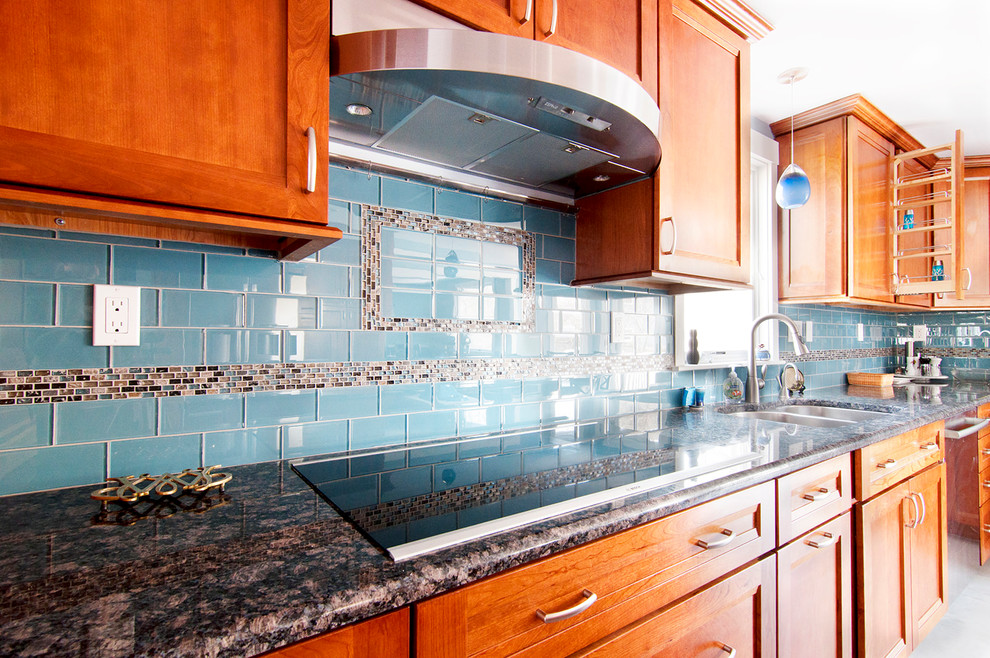 ボストンにある広いトラディショナルスタイルのおしゃれなキッチン (ダブルシンク、シェーカースタイル扉のキャビネット、中間色木目調キャビネット、御影石カウンター、青いキッチンパネル、ガラスタイルのキッチンパネル、シルバーの調理設備、セラミックタイルの床、グレーの床、黒いキッチンカウンター) の写真