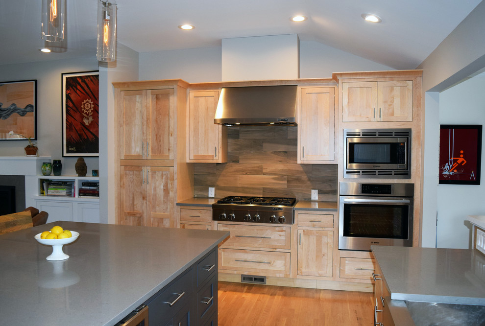 Idéer för att renovera ett stort funkis kök och matrum, med en undermonterad diskho, skåp i shakerstil, bänkskiva i kvartsit, brunt stänkskydd, rostfria vitvaror, ljust trägolv, en köksö, brunt golv, skåp i ljust trä och stänkskydd i porslinskakel