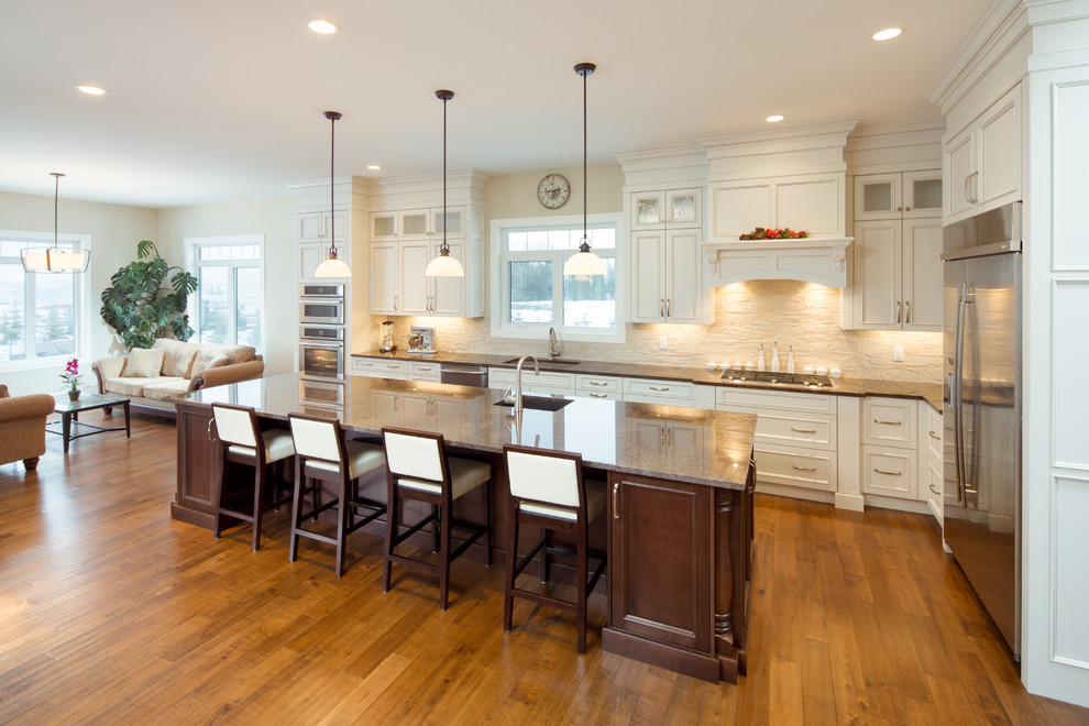 Inspiration for a mid-sized contemporary medium tone wood floor kitchen remodel with an undermount sink, white cabinets, quartzite countertops, white backsplash, stone tile backsplash, stainless steel appliances and an island