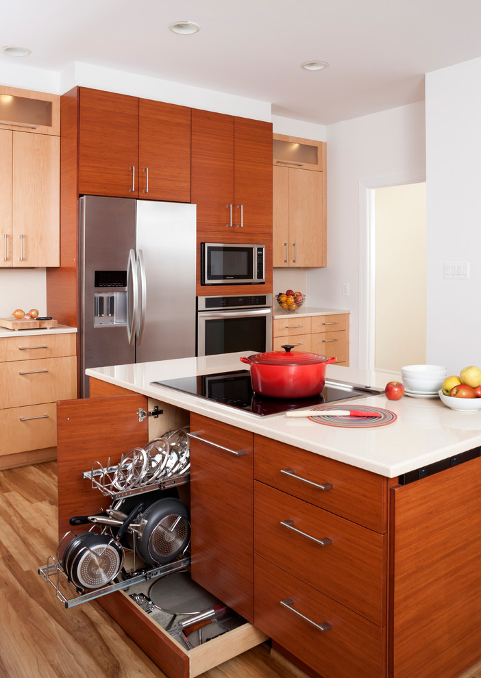 ワシントンD.C.にある広いコンテンポラリースタイルのおしゃれなキッチン (無垢フローリング、フラットパネル扉のキャビネット、中間色木目調キャビネット、白いキッチンパネル、シルバーの調理設備) の写真