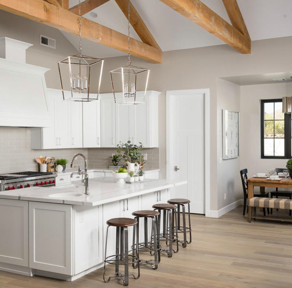 Open concept kitchen - large transitional u-shaped dark wood floor and brown floor open concept kitchen idea in San Francisco with a farmhouse sink, shaker cabinets, white cabinets, white backsplash, stainless steel appliances, an island and multicolored countertops