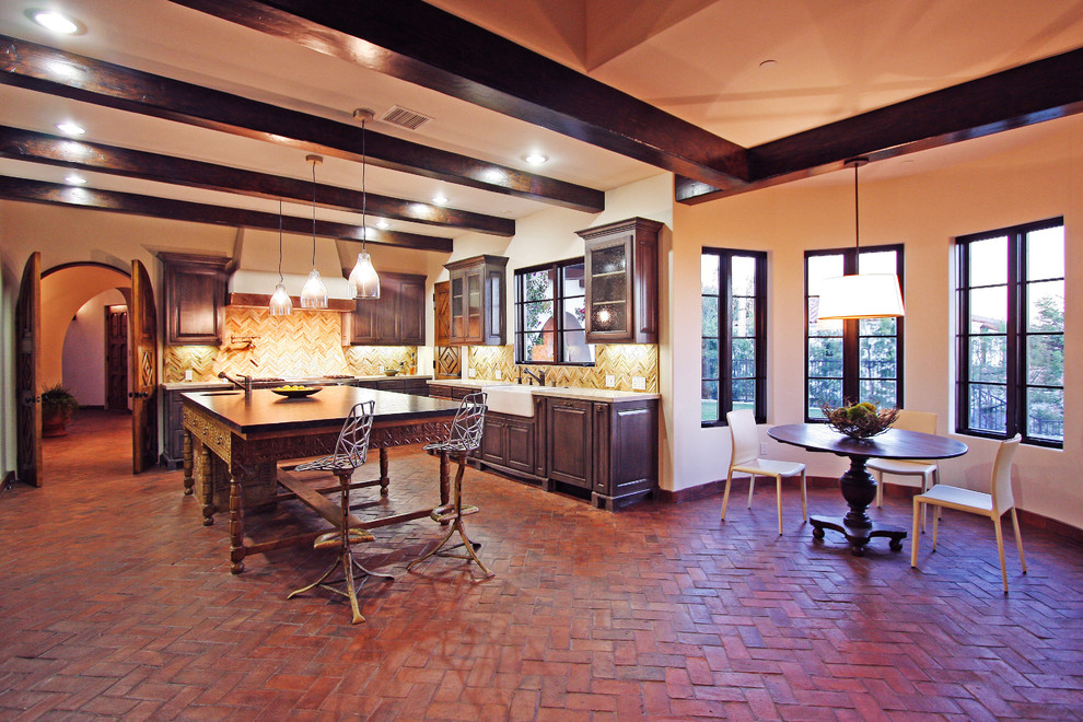 Exempel på ett stort medelhavsstil kök, med en rustik diskho, skåp i slitet trä, bänkskiva i kalksten, beige stänkskydd, stänkskydd i stickkakel, integrerade vitvaror, tegelgolv, en köksö och luckor med upphöjd panel