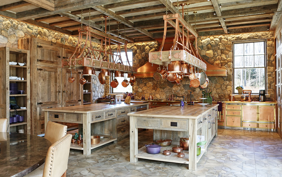 Foto di una cucina rustica con ante lisce, ante in legno scuro, top in legno, paraspruzzi con piastrelle in pietra, elettrodomestici da incasso e 2 o più isole