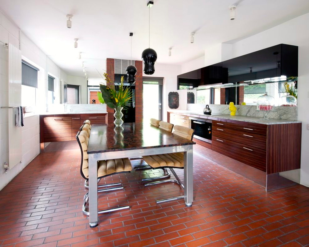 Moderne Wohnküche mit flächenbündigen Schrankfronten, dunklen Holzschränken, Granit-Arbeitsplatte und Rückwand aus Stein in Hampshire