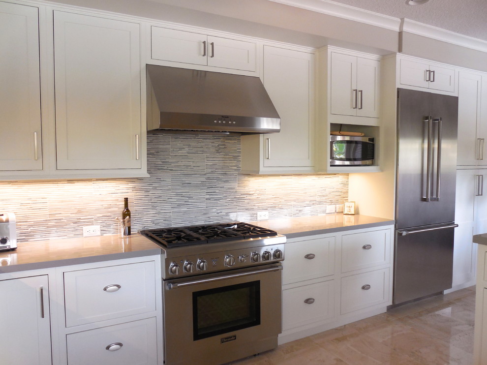 Example of a transitional eat-in kitchen design in Miami with an undermount sink, beaded inset cabinets, white cabinets, quartz countertops, gray backsplash and stainless steel appliances