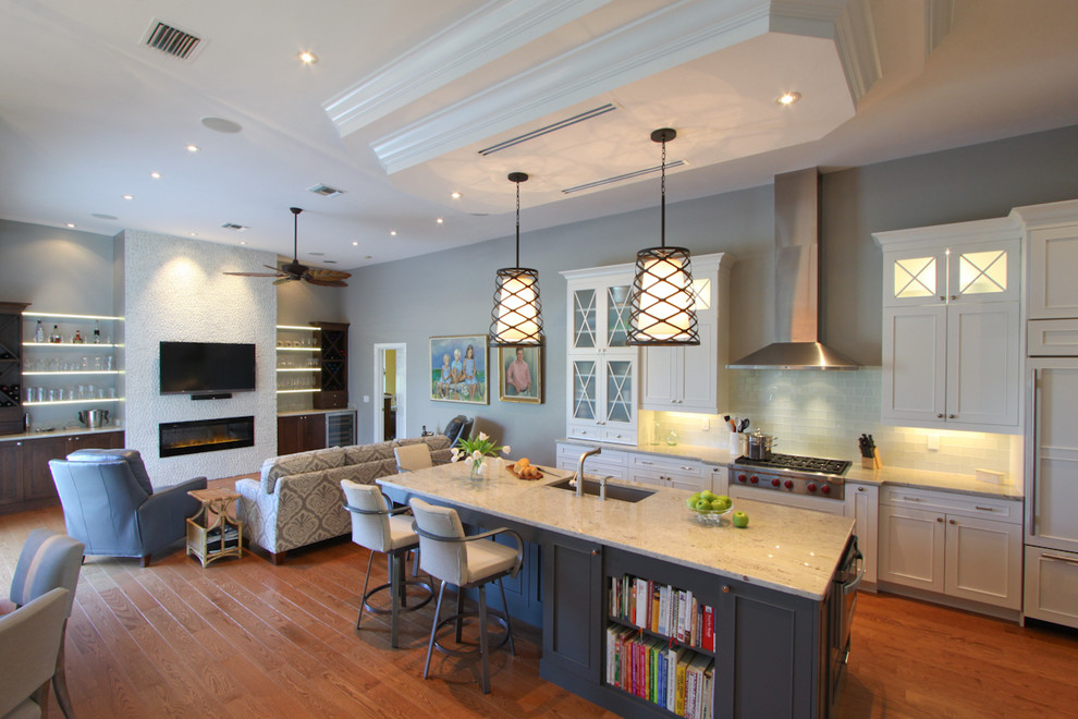 Idéer för ett modernt kök, med skåp i shakerstil, vita skåp, en köksö, en undermonterad diskho, granitbänkskiva, vitt stänkskydd, stänkskydd i tunnelbanekakel, rostfria vitvaror, mellanmörkt trägolv och brunt golv