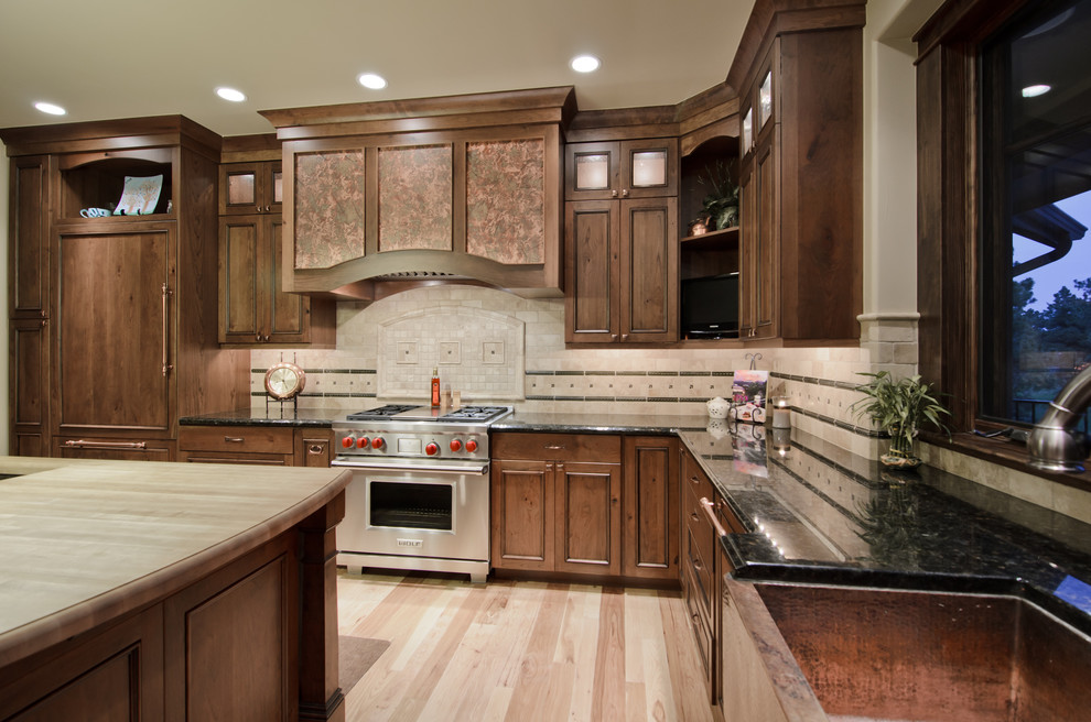 Kitchen - traditional l-shaped kitchen idea in Denver with paneled appliances, a farmhouse sink and dark wood cabinets