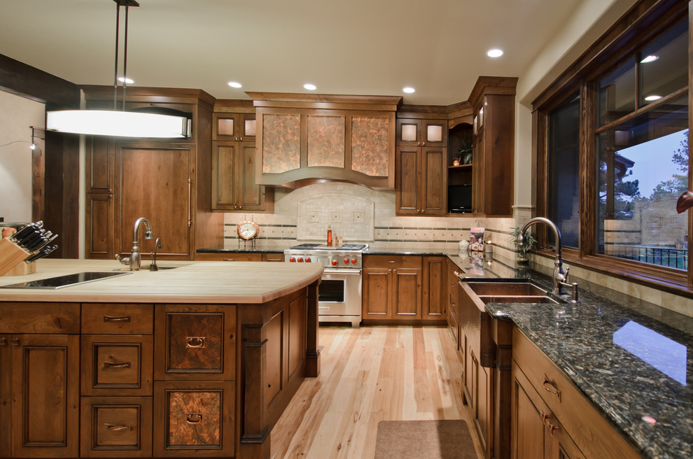 Rustikale Küche in L-Form mit Elektrogeräten mit Frontblende, Doppelwaschbecken, Arbeitsplatte aus Holz, dunklen Holzschränken und Mauersteinen in Denver