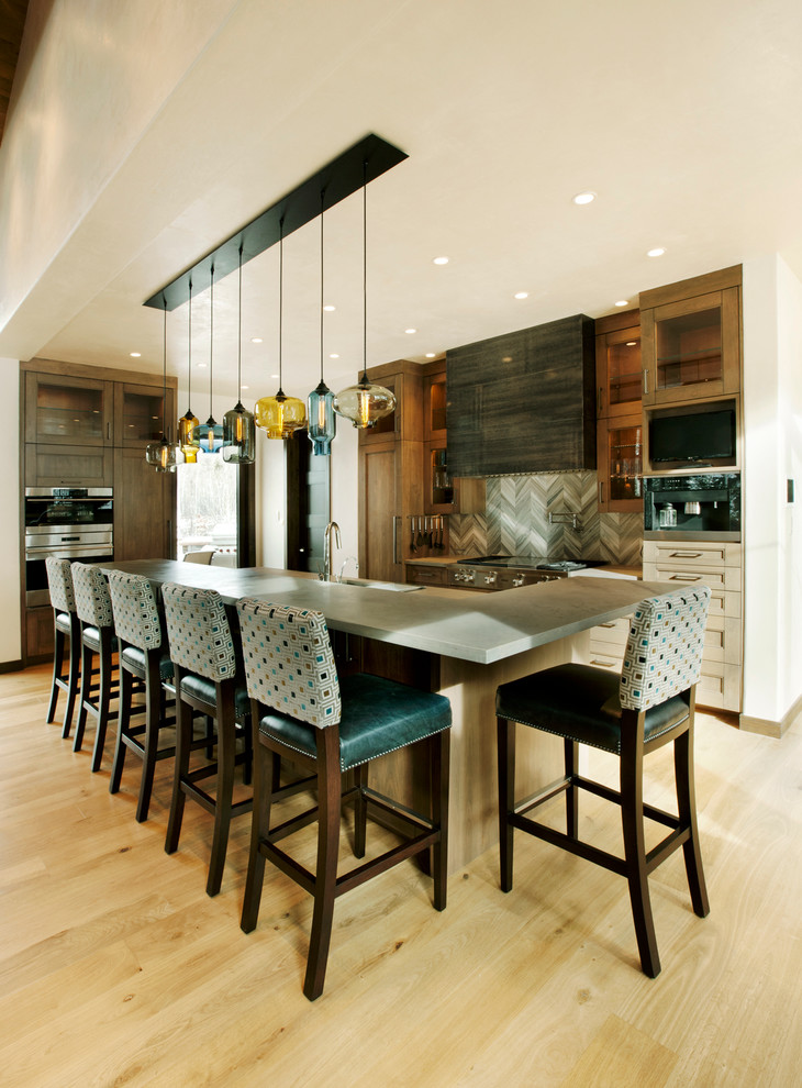 Exempel på ett mellanstort rustikt kök, med en undermonterad diskho, skåp i mellenmörkt trä, grått stänkskydd, stänkskydd i stenkakel, integrerade vitvaror, mellanmörkt trägolv och en köksö