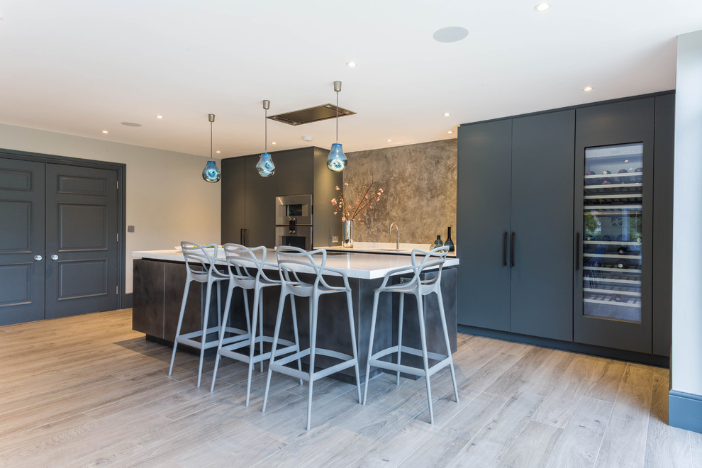 Immagine di una cucina contemporanea di medie dimensioni con lavello sottopiano, ante lisce, paraspruzzi grigio, elettrodomestici da incasso, pavimento beige, top bianco e ante blu