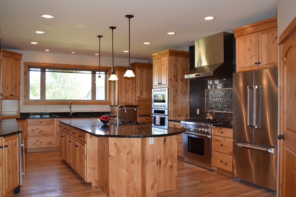Kitchen - large traditional u-shaped medium tone wood floor kitchen idea in Other with raised-panel cabinets, medium tone wood cabinets, black backsplash, ceramic backsplash, stainless steel appliances, an island and granite countertops