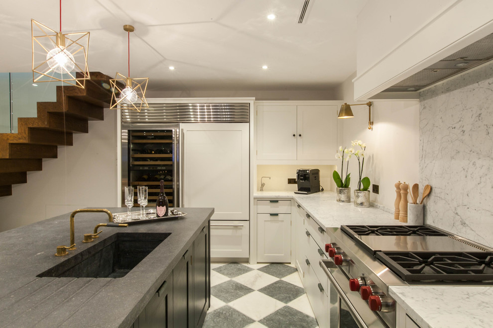 Imagen de cocina moderna de tamaño medio con fregadero integrado, puertas de armario blancas, encimera de granito, salpicadero blanco y una isla