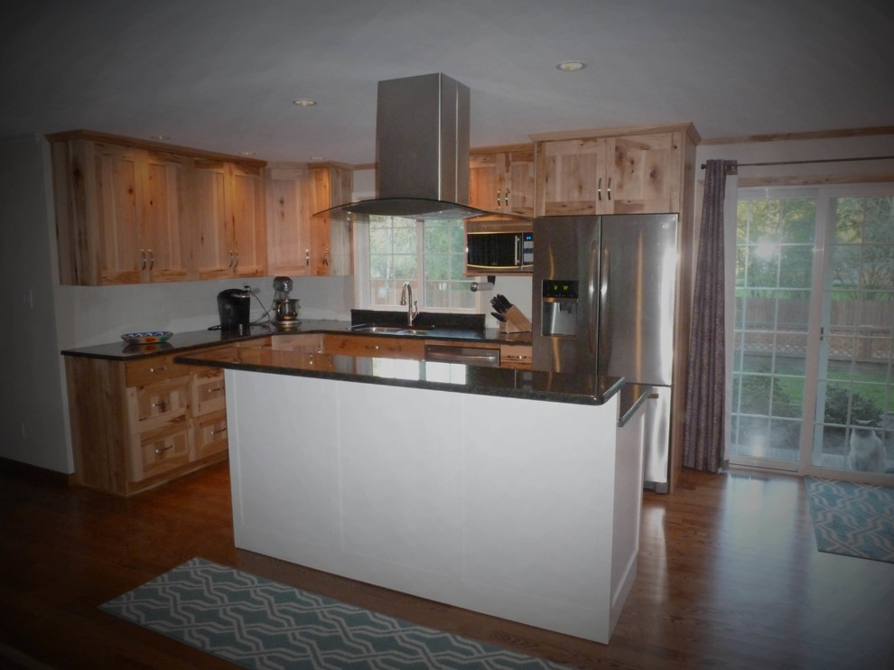 Inredning av ett rustikt stort kök, med en dubbel diskho, skåp i shakerstil, skåp i ljust trä, granitbänkskiva, rostfria vitvaror, mellanmörkt trägolv, en köksö och brunt golv