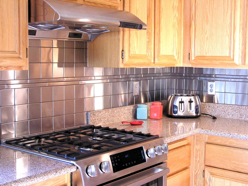 Example of a minimalist eat-in kitchen design in Atlanta with light wood cabinets, metallic backsplash, metal backsplash and stainless steel appliances