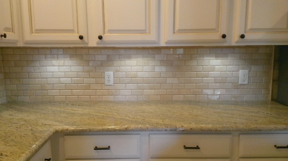 Example of a mid-sized classic l-shaped open concept kitchen design in Austin with raised-panel cabinets, light wood cabinets, granite countertops, beige backsplash, subway tile backsplash and an island