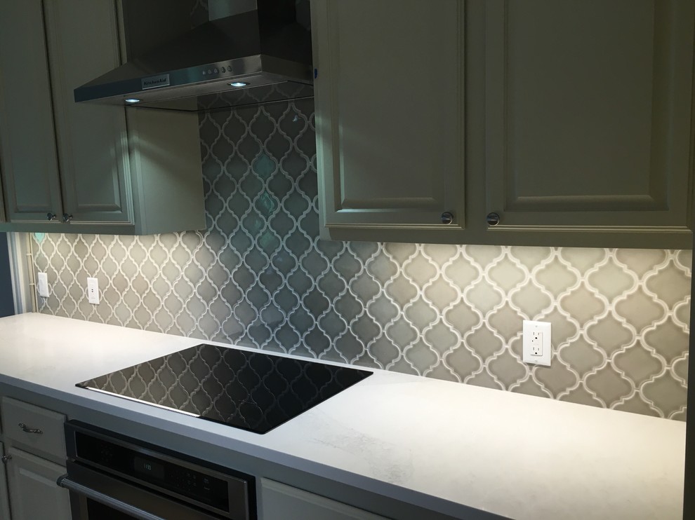 Modern inredning av ett mellanstort kök, med luckor med upphöjd panel, grå skåp, bänkskiva i kvarts, grått stänkskydd, stänkskydd i keramik och rostfria vitvaror