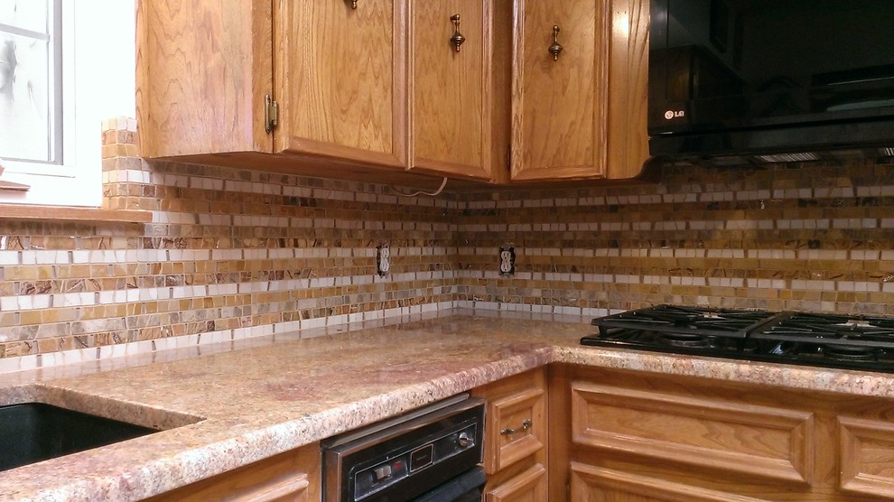 Inredning av ett modernt avskilt kök, med en undermonterad diskho, luckor med infälld panel, skåp i mellenmörkt trä, granitbänkskiva, flerfärgad stänkskydd och rostfria vitvaror