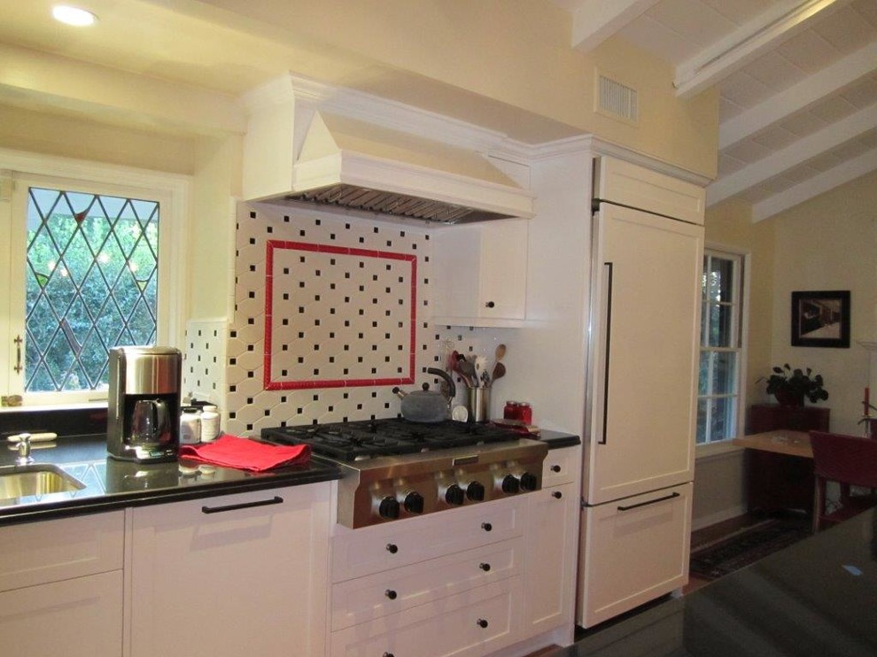 Modelo de cocina contemporánea con armarios estilo shaker, puertas de armario blancas, encimera de granito, salpicadero blanco y electrodomésticos de acero inoxidable