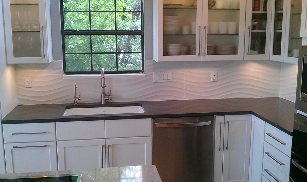 Modern inredning av ett kök, med en undermonterad diskho, luckor med infälld panel, vita skåp, bänkskiva i kvartsit, vitt stänkskydd, stänkskydd i keramik och rostfria vitvaror