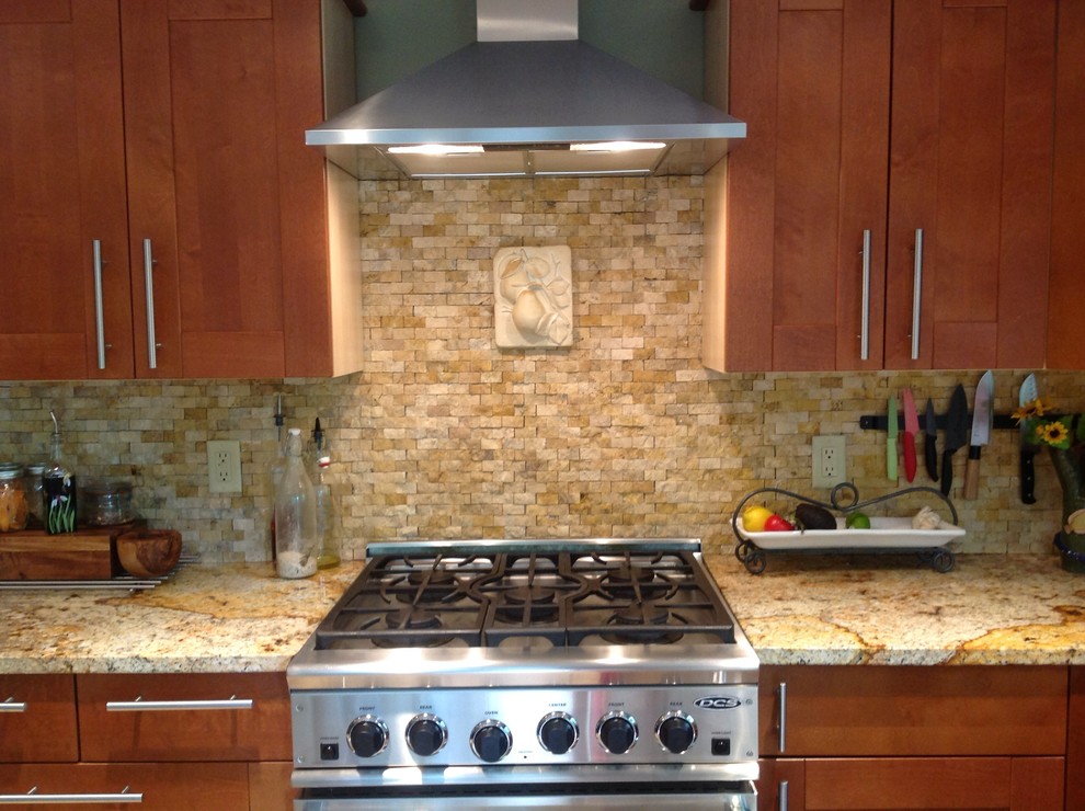 Example of an arts and crafts kitchen design in Boston with recessed-panel cabinets, medium tone wood cabinets, granite countertops, beige backsplash, stone tile backsplash and stainless steel appliances