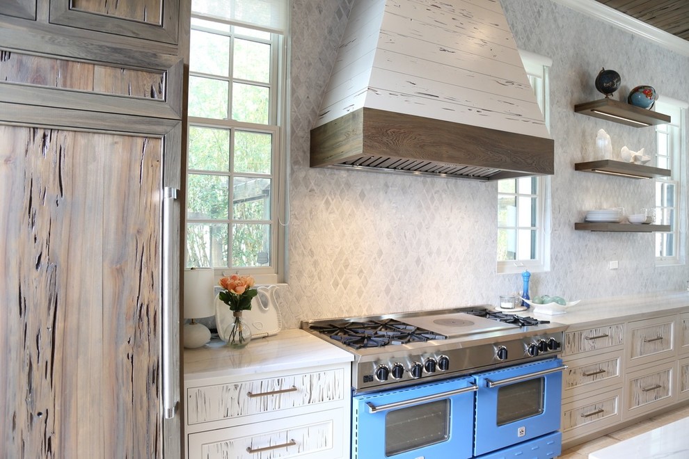 Inspiration for a large industrial l-shaped eat-in kitchen remodel in New York with distressed cabinets, white backsplash, stone tile backsplash, colored appliances and an island