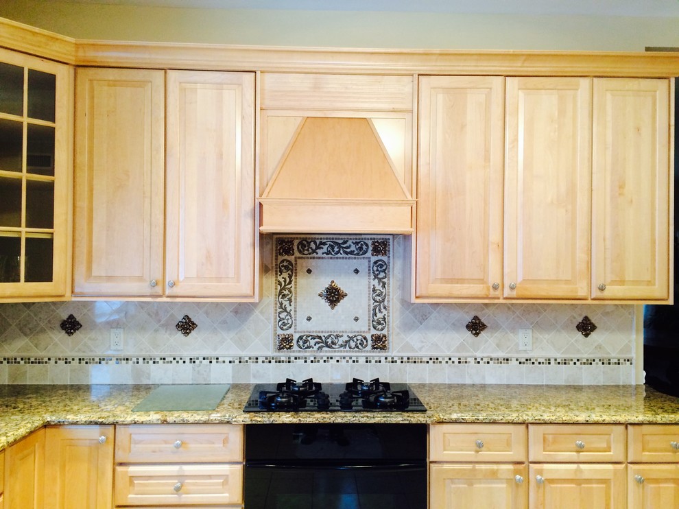 Cette photo montre une cuisine chic avec un plan de travail en granite, une crédence beige et une crédence en dalle métallique.