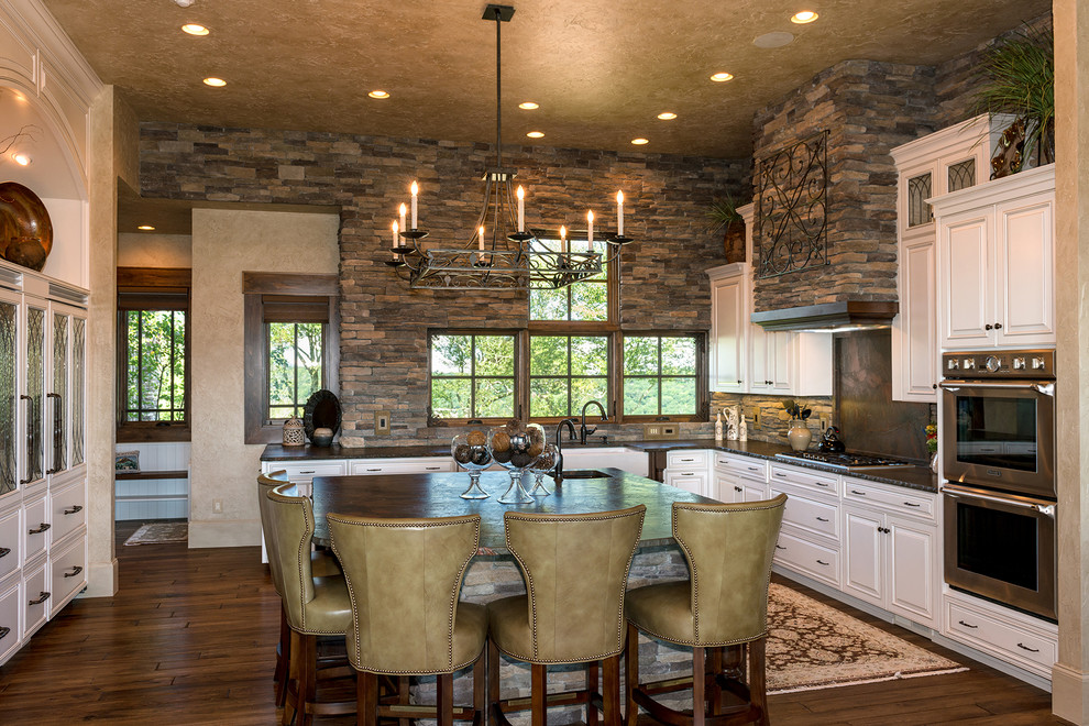 Foto di una cucina classica con lavello stile country, ante con bugna sagomata, ante bianche e top in granito