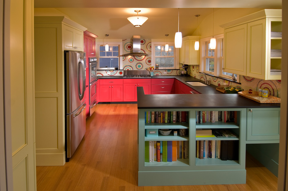 Example of a trendy u-shaped kitchen design in Seattle with an undermount sink, recessed-panel cabinets, red cabinets, multicolored backsplash, mosaic tile backsplash and stainless steel appliances