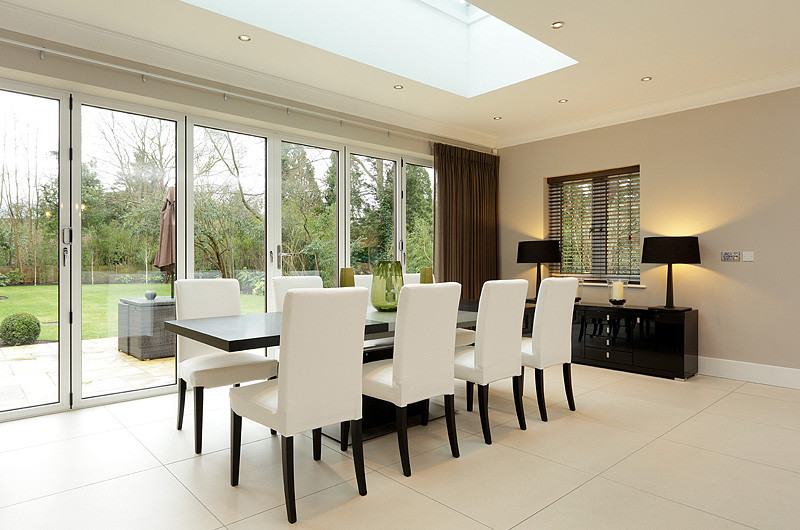 Cette image montre une grande salle à manger ouverte sur la cuisine minimaliste avec un sol en carrelage de porcelaine.