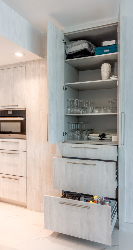 Cette image montre une cuisine encastrable minimaliste de taille moyenne avec des portes de placard blanches, une crédence blanche, îlot et un plan de travail blanc.