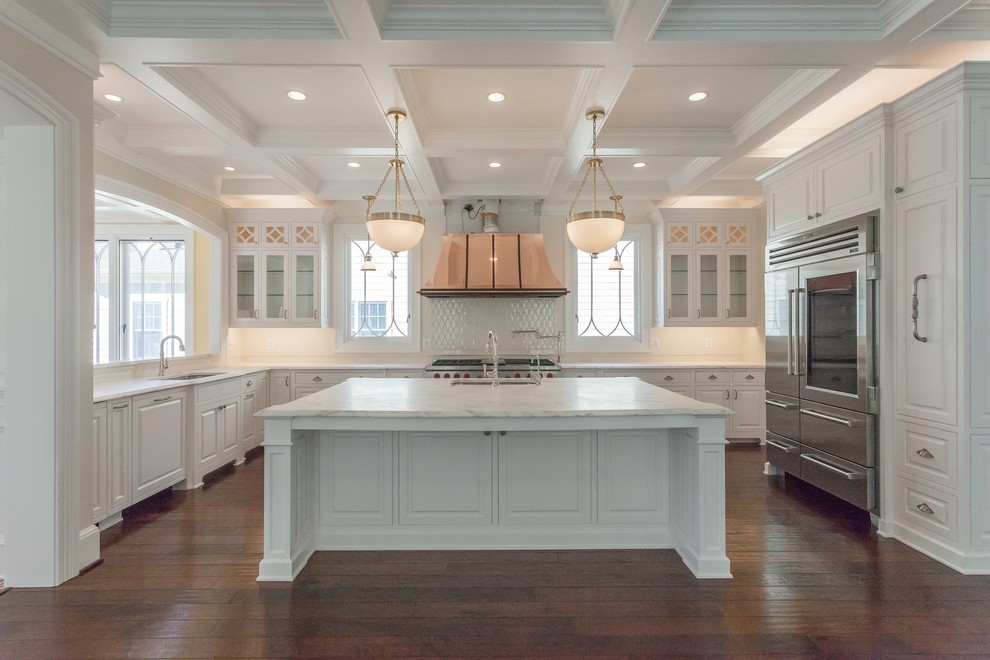 Inspiration for a traditional u-shaped open plan kitchen in DC Metro with a submerged sink, white cabinets, stainless steel appliances, medium hardwood flooring, an island and brown floors.