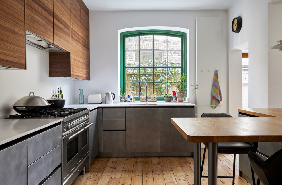 ロンドンにあるコンテンポラリースタイルのおしゃれなキッチン (アンダーカウンターシンク、フラットパネル扉のキャビネット、グレーのキャビネット、木材カウンター、シルバーの調理設備、無垢フローリング、茶色い床、茶色いキッチンカウンター) の写真